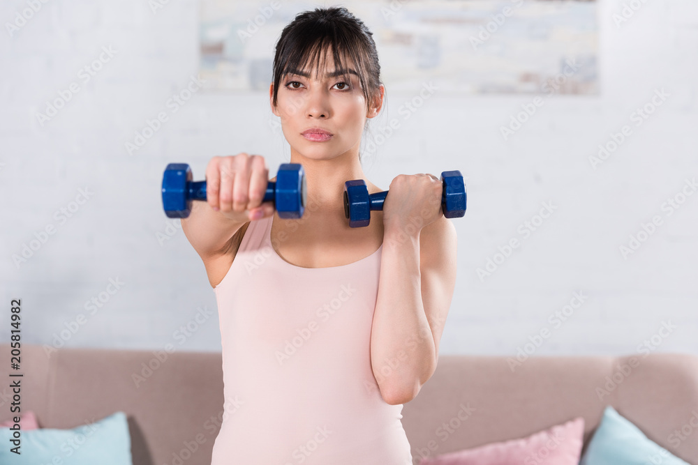 attractive young woman doing exercise with dumbbells at home attractive young woman doing exercise with dumbbells at home