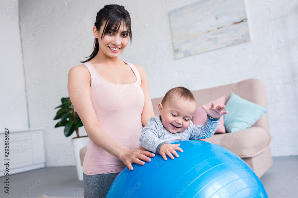 young sporty mother and little child with fit ball at home young sporty mother and little child with fit ball at home