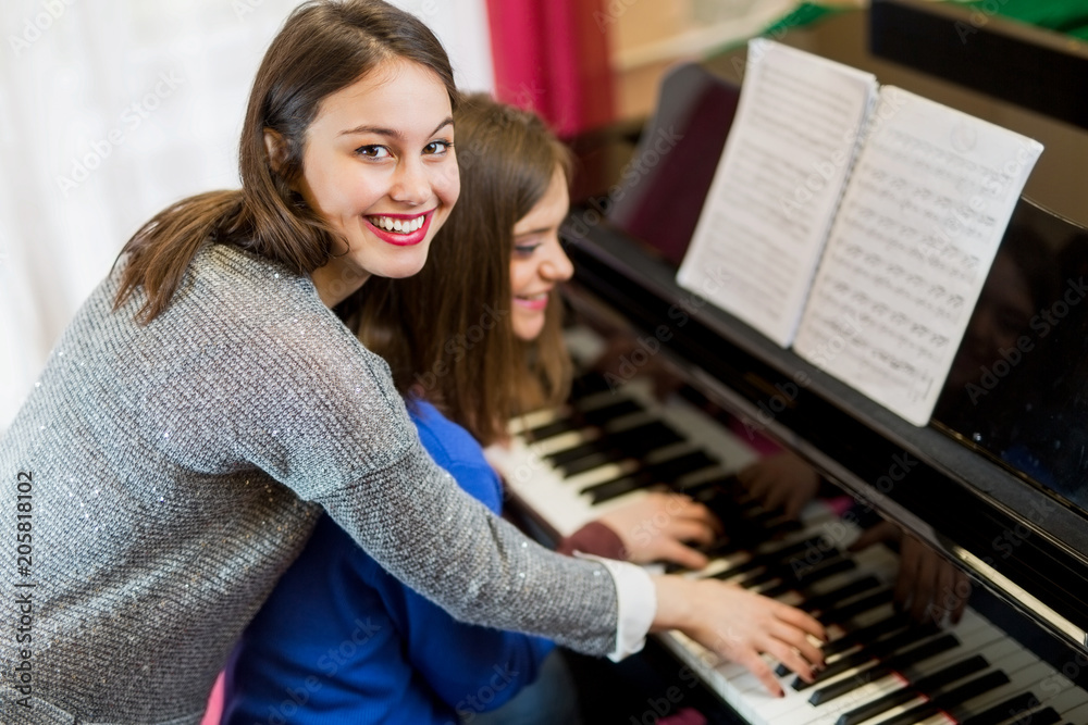 Fotografie Two female playing the piano.