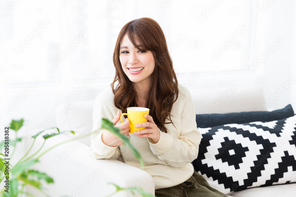 部屋で飲み物を飲む女性 部屋で飲み物を飲む女性