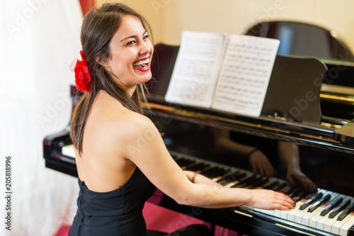 Young beauty plays the piano