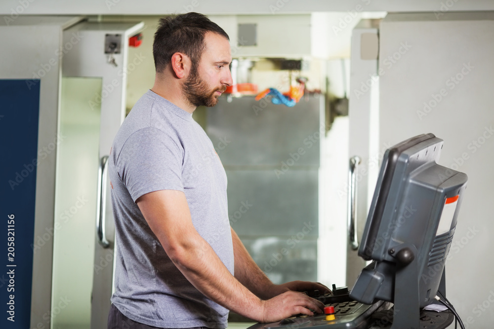 Engineer working on CNC machine Engineer working on CNC machine