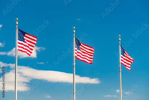 Flags of the United States waving over blue sky in Washington DC