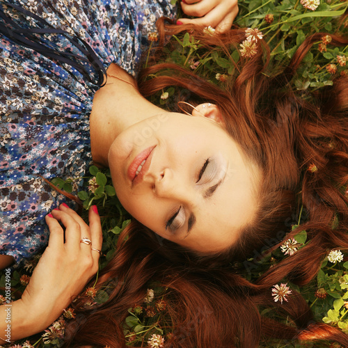young beautiful girl lays on a grass 