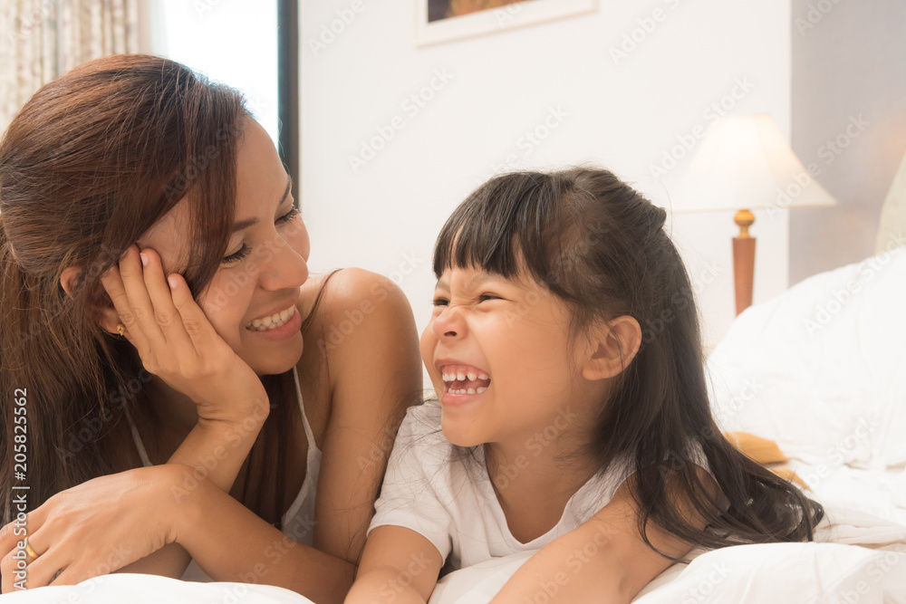 Mother and daughter enjoy in bed at home Mother and daughter enjoy in bed at home