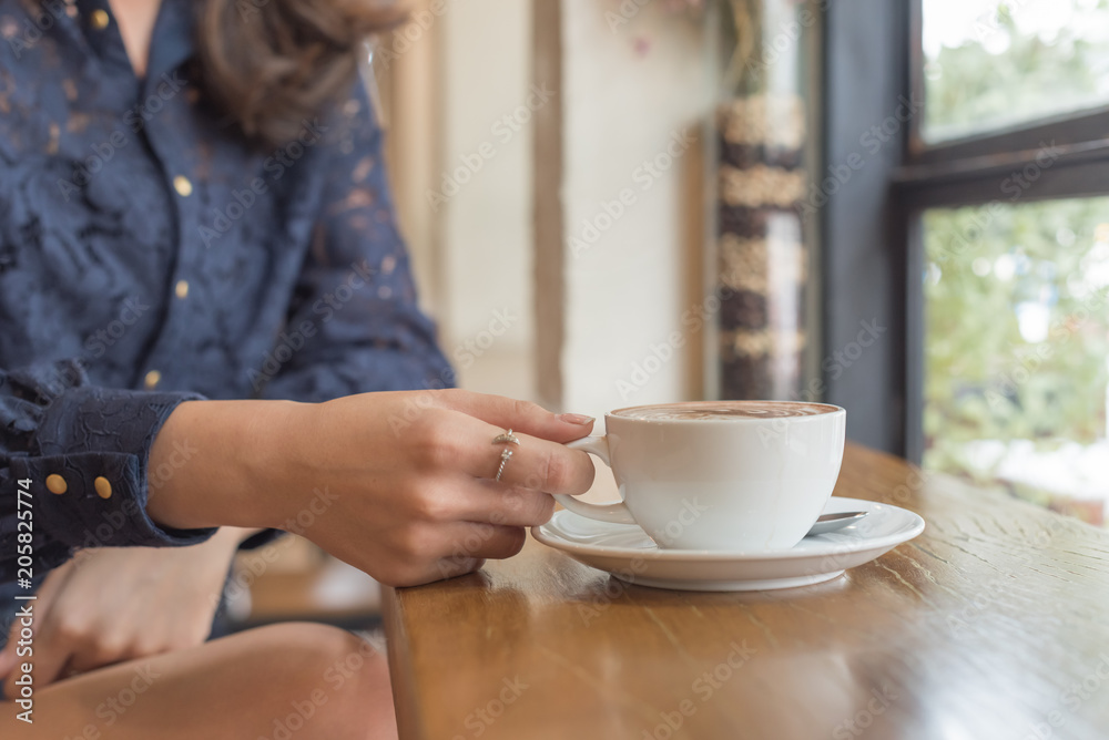Beautiful cute girl in the cafe near the window with coffee Beautiful cute girl in the cafe near the window with coffee