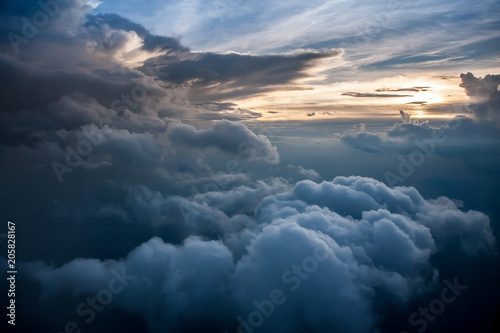 Fototapeta Naklejka Na Ścianę i Meble -  Aerial view of a cloudy sunset while flying above the clouds
