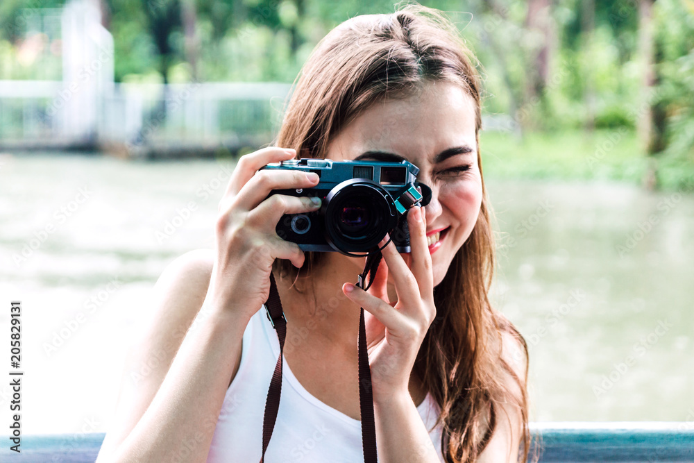 Woman taking picture with camera in park Woman taking picture with camera in park