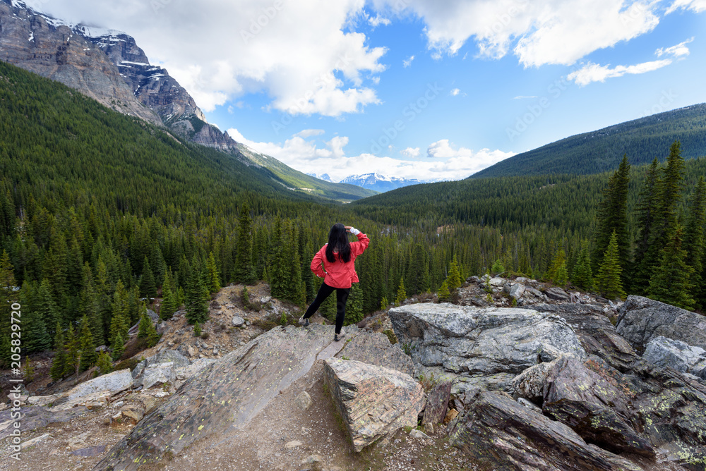 A Woman hiker enjoys beautiful mountain view at Moraine Lake, Banff National Park, Canada