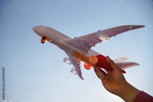 young hands playing airplane, sky toy with clouds