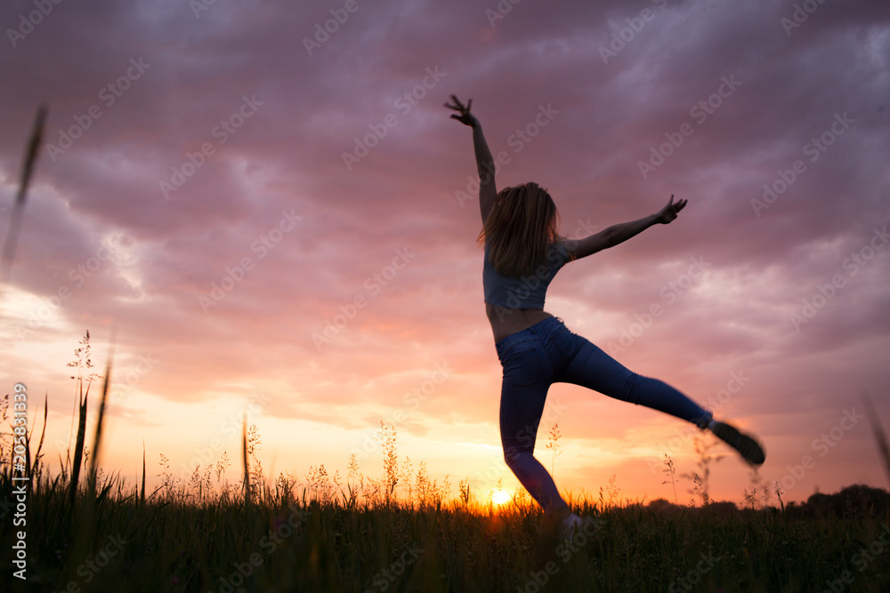 Silhouette of a young woman , sunset sky Silhouette of a young woman , sunset sky