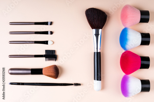 Cosmetics accessories for makeup on beige background flat lay. Set of cosmetics brushes. Minimal composition. Fashion and beauty blogging concept. Top view