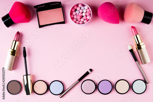 Frame of makeup products and decorative cosmetics on pink background flat lay. Fashion and beauty blogging concept. Top view, copy space