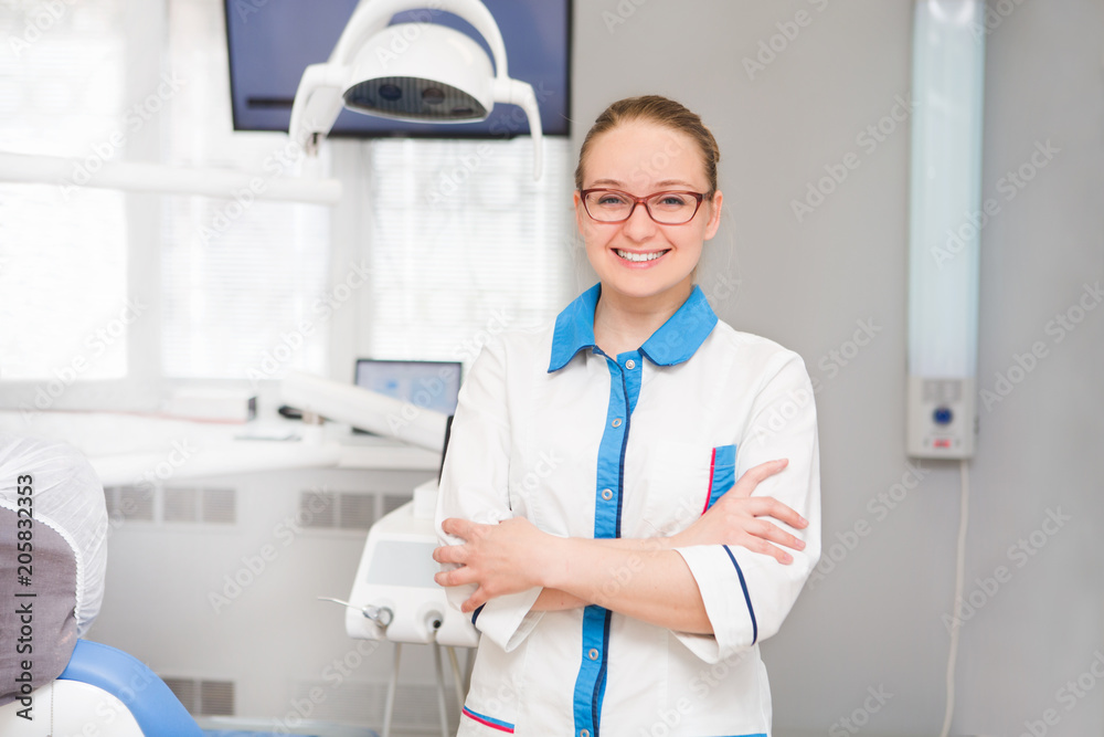 Portrait of female dentist with tools in her dentist office and looking at camera. Medicine, stomatology, healthcare concept. Portrait of female dentist with tools in her dentist office and looking at camera. Medicine, stomatology, healthcare concept.