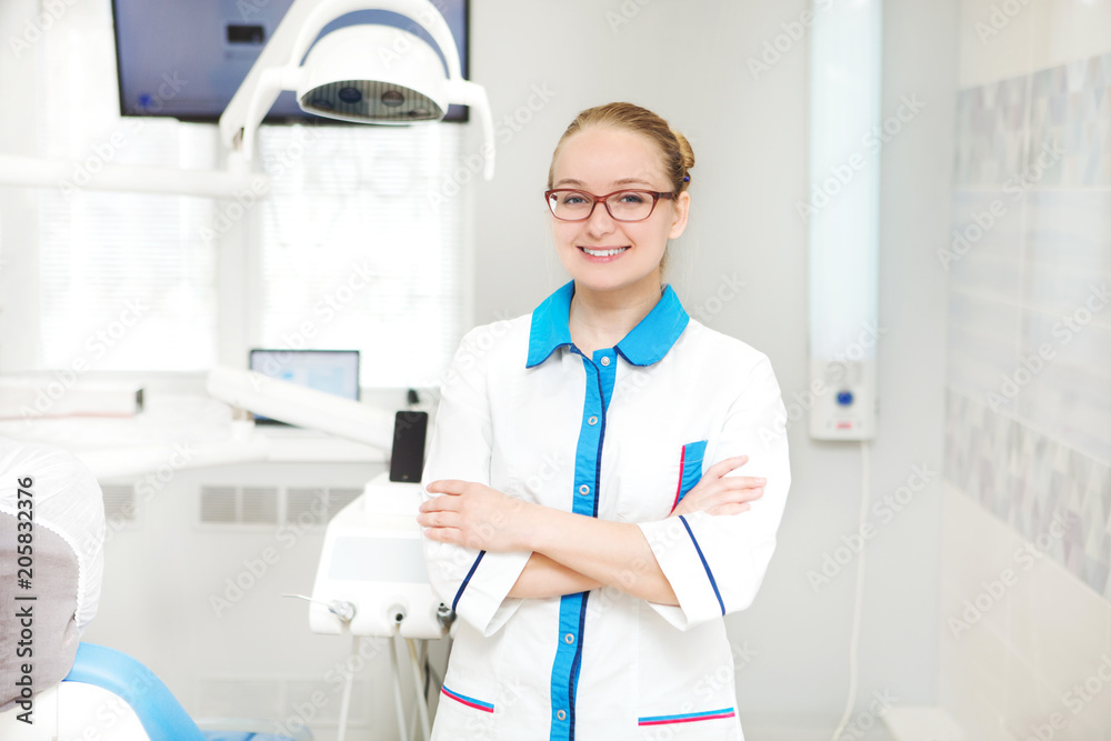 Portrait of female dentist with tools in her dentist office and looking at camera. Medicine, stomatology, healthcare concept. Portrait of female dentist with tools in her dentist office and looking at camera. Medicine, stomatology, healthcare concept.