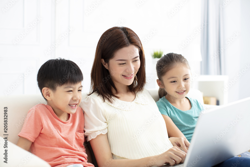 mother with children in living room with laptop mother with children in living room with laptop