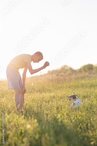 teenager playing with a dog in the nature,