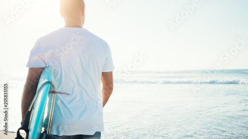 Photography Young guy surfer looking to the ocean with surfboard