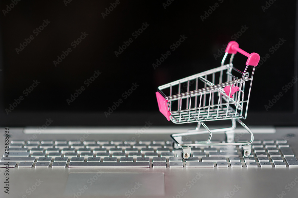 Supermarket trolley for products on the laptop keyboard close-up