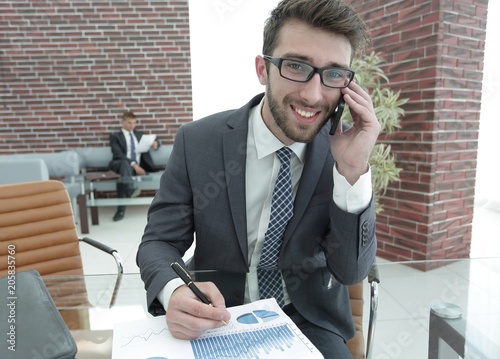 businessman talking on smart phone in modern office photo