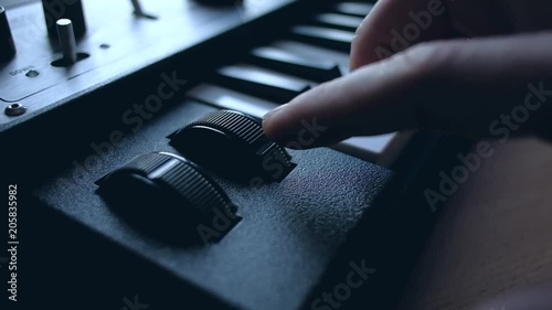 Man playing on musical synthesizer. Slowmotion. Push buttton of vibrato. photo