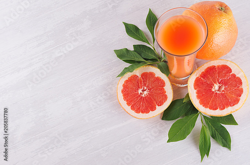Colorful fruit pink juice with grapefruits and green leaves as fresh healthy summer background. Top view, closeup.