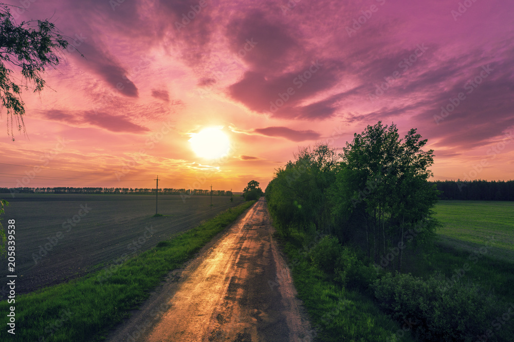 Aerial view of a country road at sunset. Rural evening landscape