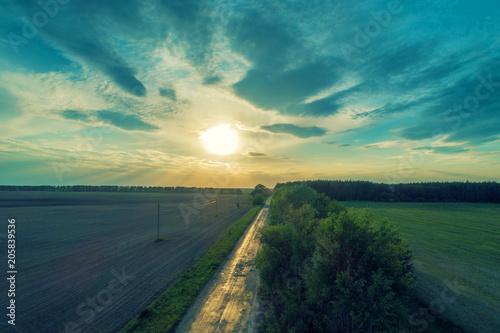 Aerial view of a country road at sunset. Rural evening landscape