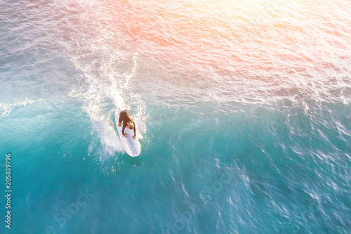 Surfer in the ocean in the sunlight, top view