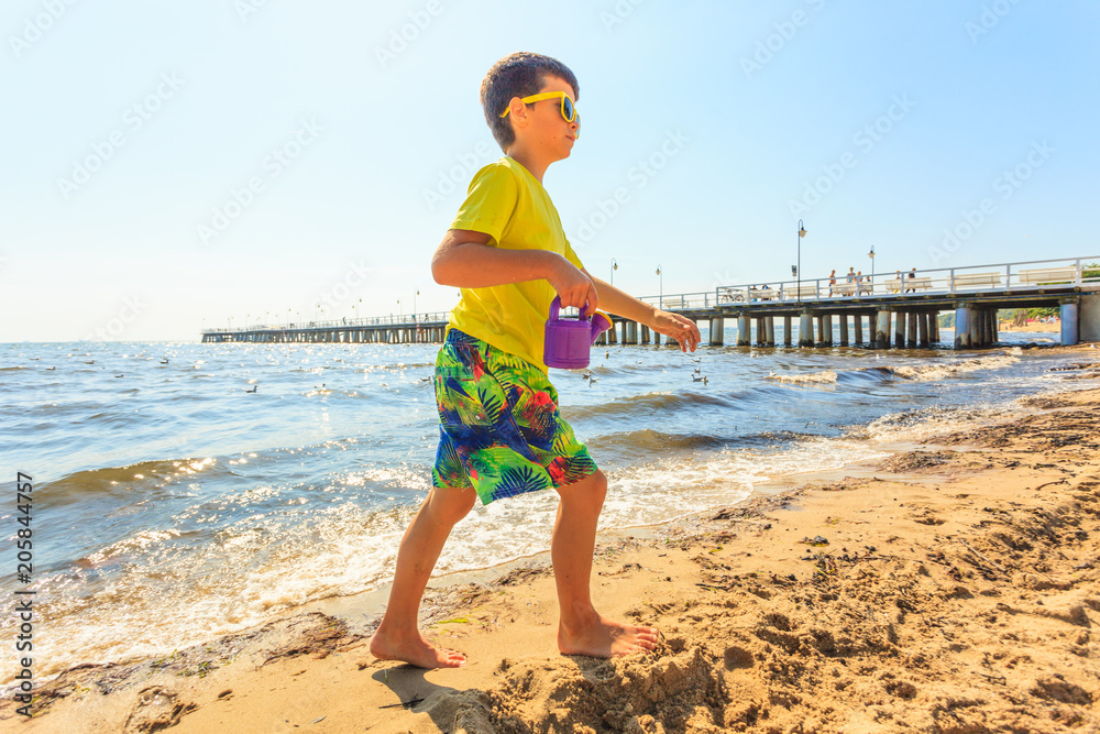 Boy walking on beach.