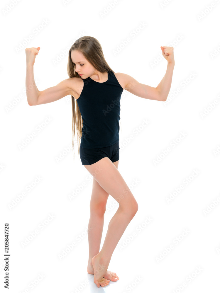 A little girl shows her muscles.