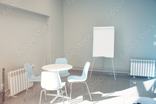 Empty seminar room with chairs and whiteboard for a presentation. Flipchart in empty poor office © Kseniia