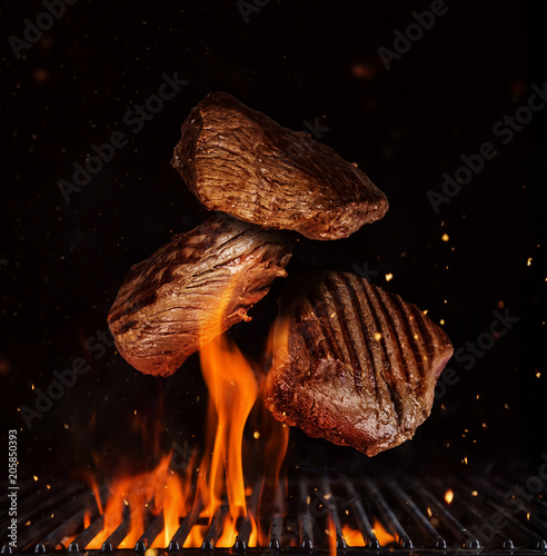 Photography Flying pieces of beef rump steaks on black