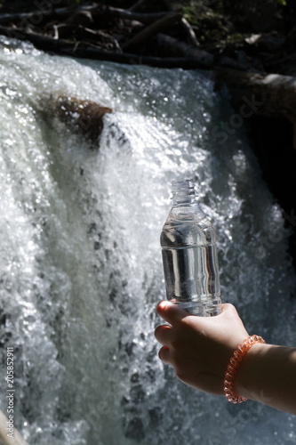 A bottle of drinking water on a clean mountain stream.