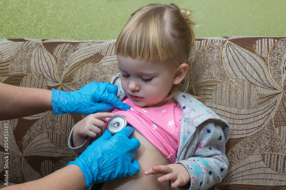 The pediatrician examines the sick girl's breasts using a phonostage. Home visit. The pediatrician examines the sick girl's breasts using a phonostage. Home visit.