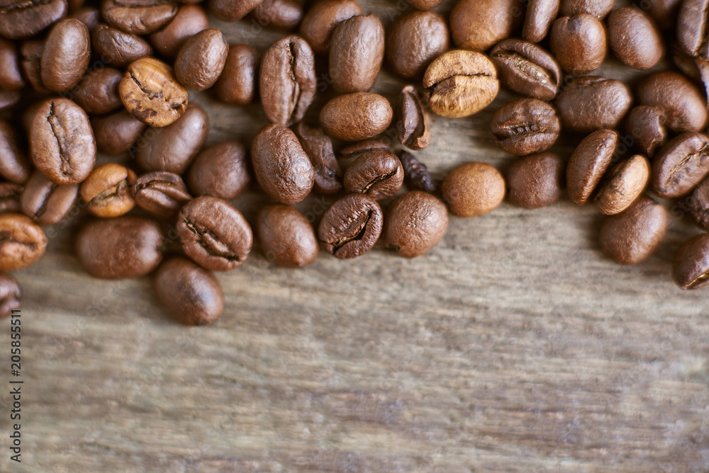Roasted coffee beans on rustic wooden background. Food ingredients, top view, space for text Roasted coffee beans on rustic wooden background. Food ingredients, top view, space for text