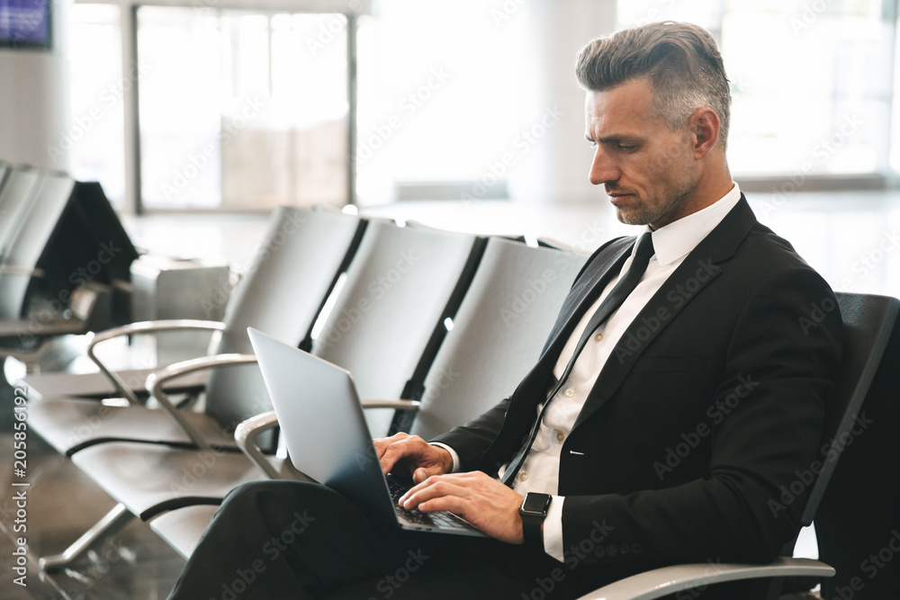 Fototapeta premium Confident businessman using laptop computer