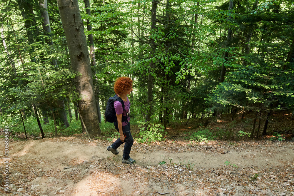 Woman hiking on a mountain trail Woman hiking on a mountain trail