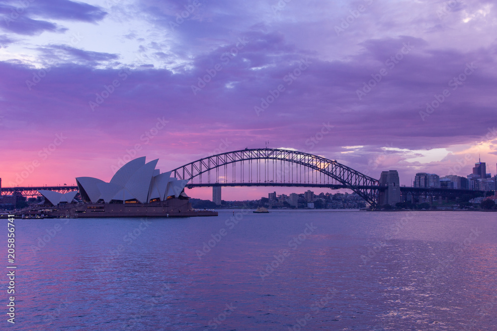 Naklejka premium opera house and harbour bridge in Sydney at sun clouds in twilight time,They are iconic landmarks of Australia .Australia