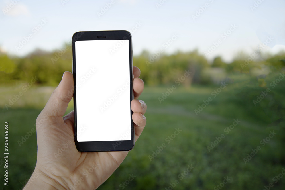 Modern Smartphone Device in man hand on summer green background. Mock up