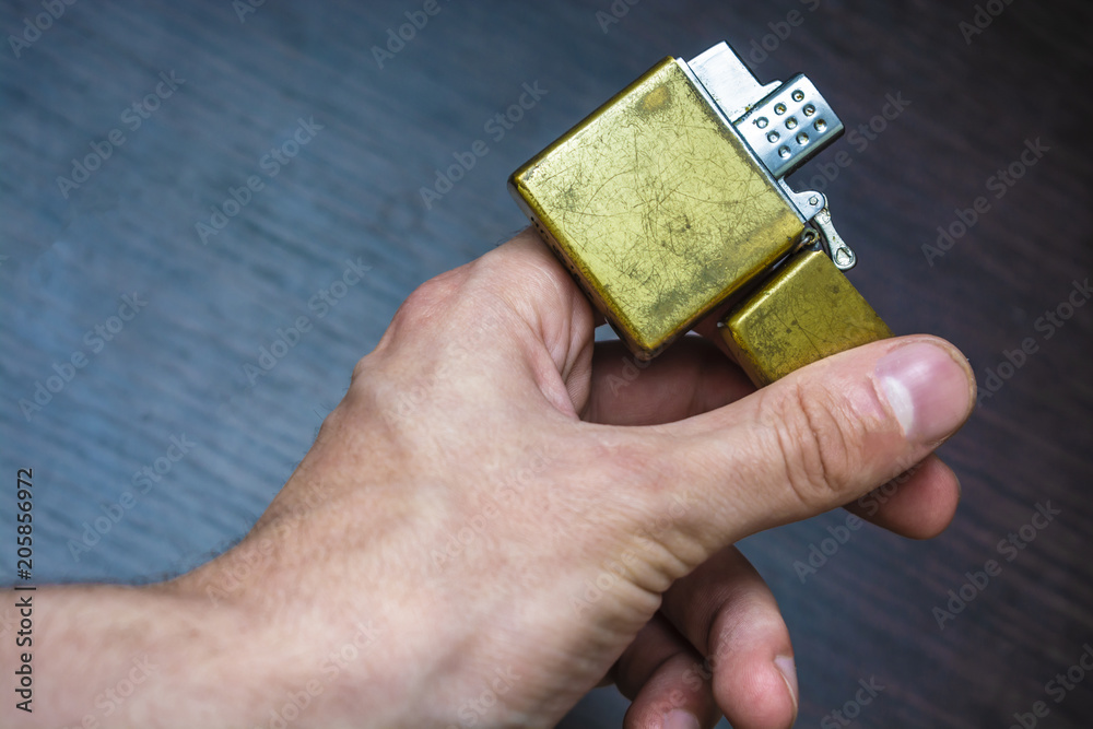 Fototapeta premium hand-held golden folding lighter