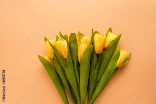 Flat lay, top view yellow flowers on brown color background with copyspace. Selective focus. Place for text.
