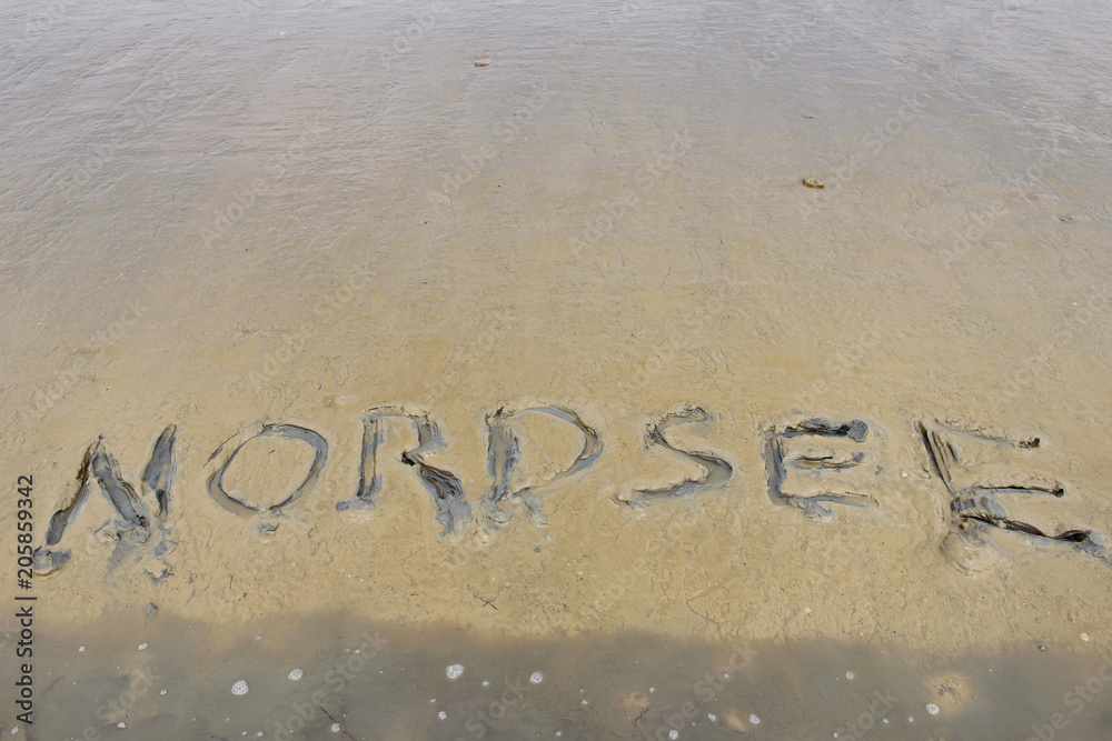 Fototapeta premium Low tide beach of north sea with the word 