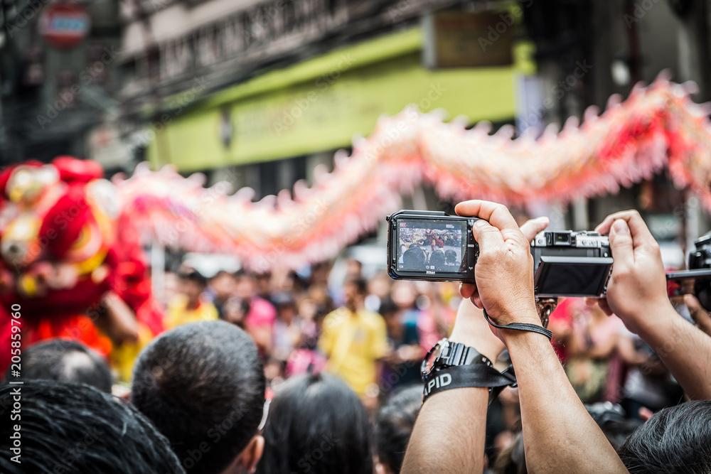Fototapeta premium Taking photos and videos using the phone during the Chinese New Year celebration at Manila Chinatown