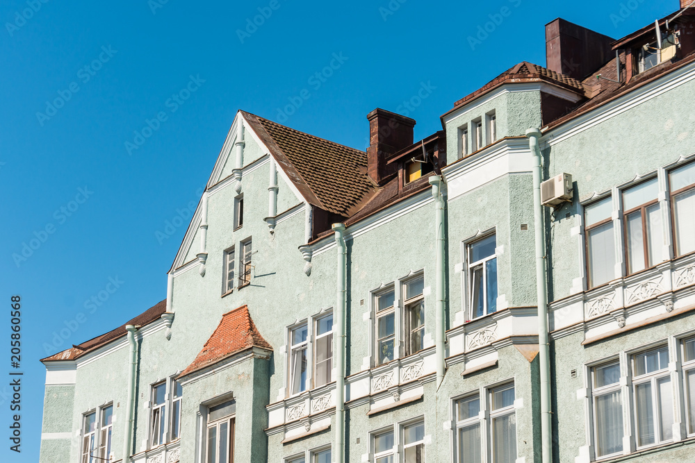 Fototapeta premium Houses in an old European green style with typical roof shapes and windows.