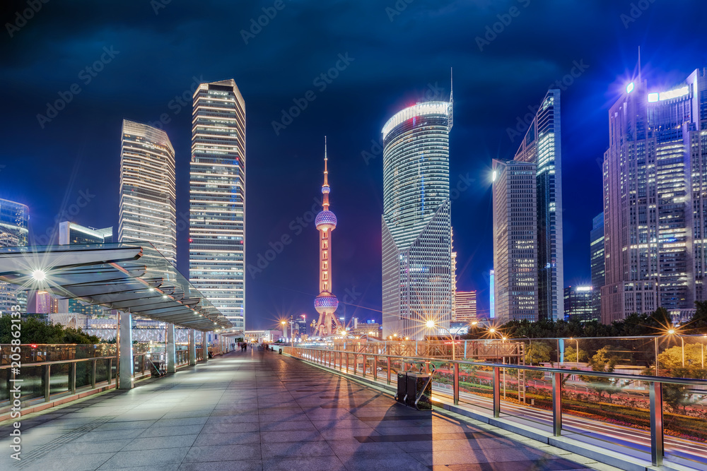 Naklejka premium Wieczorem widok na oświetloną panoramę Pudong, finansowej dzielnicy Szanghaju w Chinach