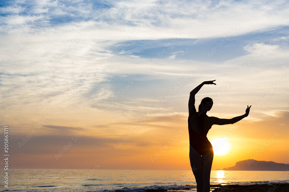 Sunset yoga woman meditation on Ocean coast