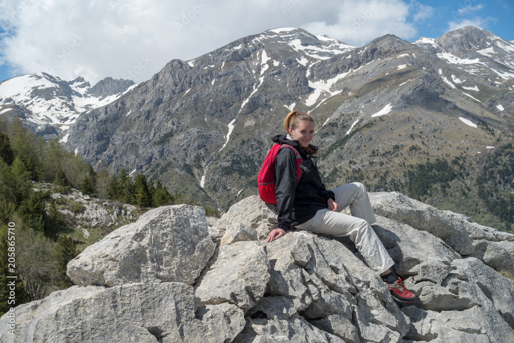 Female hiker takes a break and enjoys mountain views, Alps, Liguria, Italy