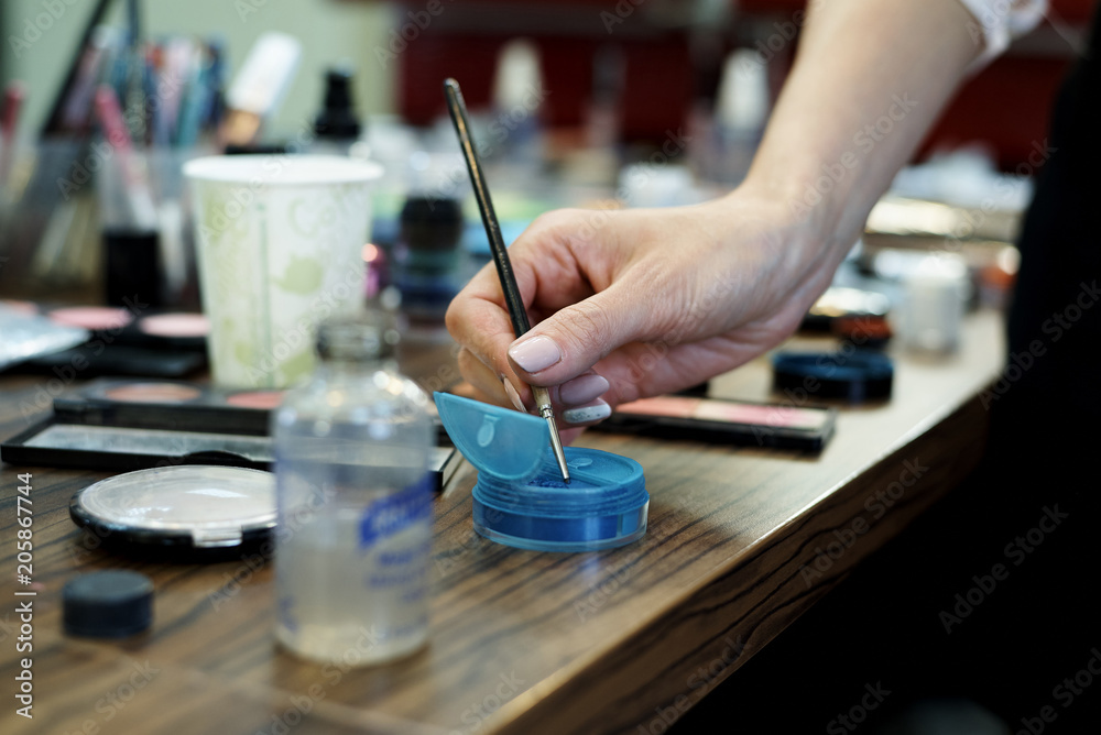 Fototapeta premium Hands make-up artist with a brush and make-up cosmetics on the table.