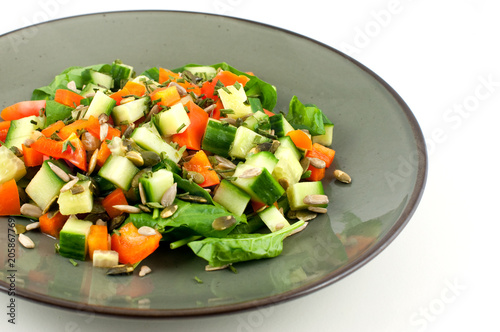 Green plate with a healthy salad isolated on white background